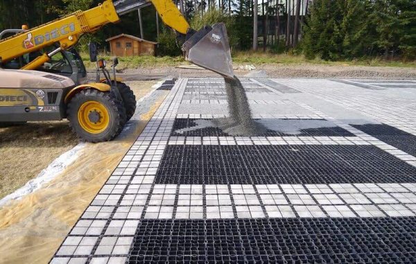 Заполнение ячеек газонной решетки погрузчиком